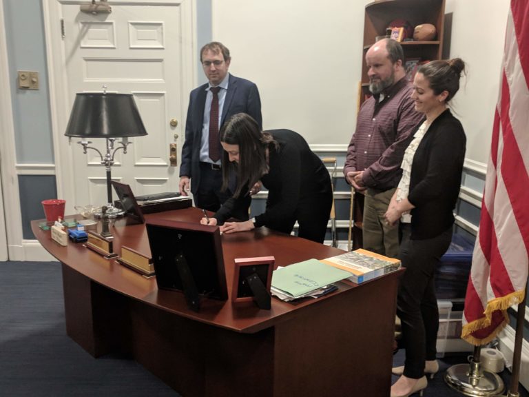 Gilman Square Neighborhood Association Steering Committee members and Executive Director of Strategic Planning and Community Development signing an agreement to help the two organizations collaborate more effectively over the next year.